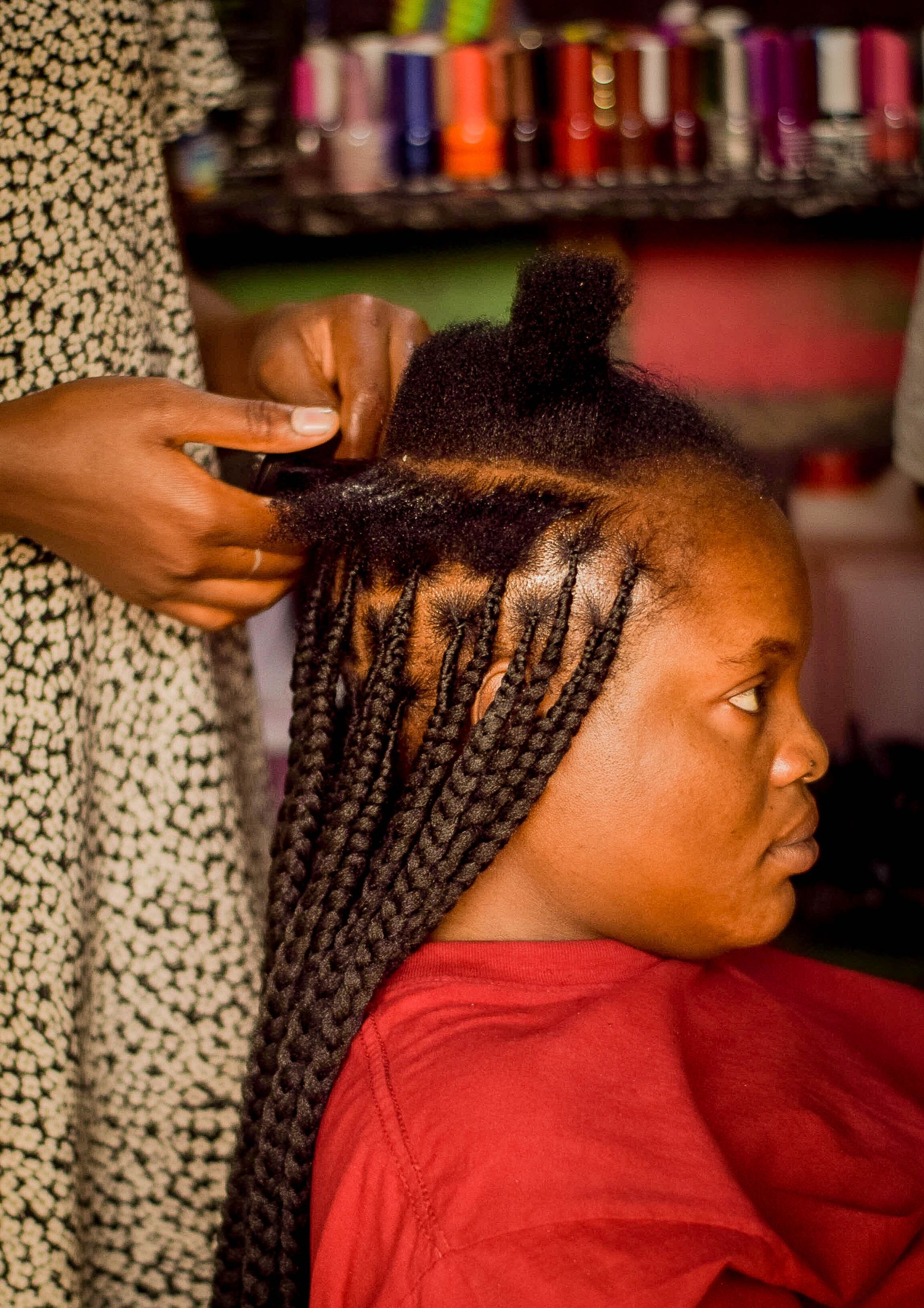 Stylist braiding a client's hair in the salon